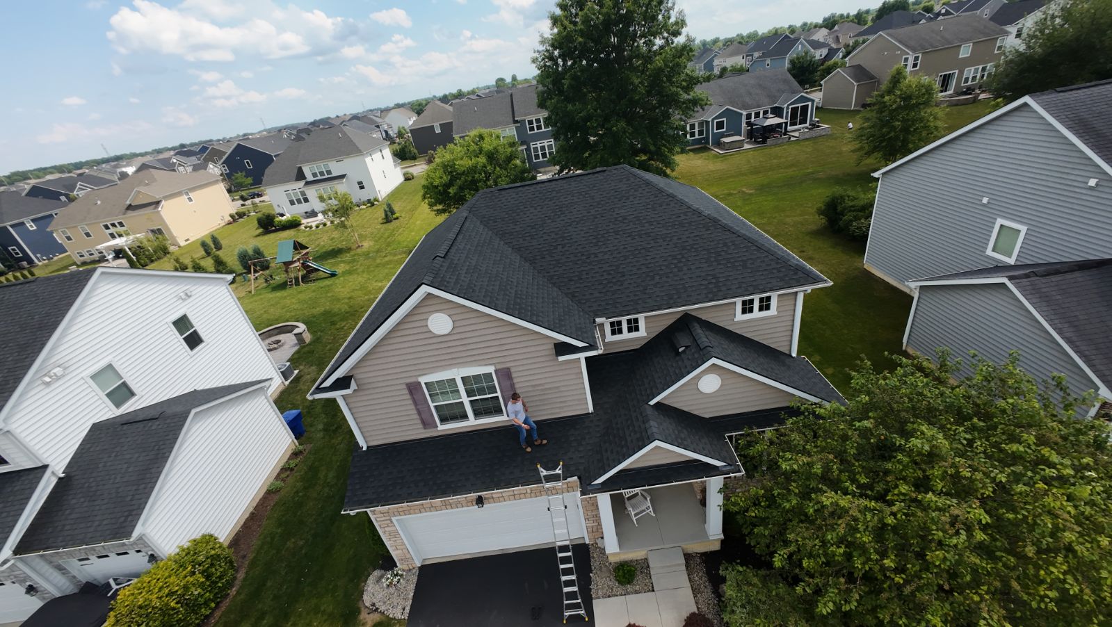 Completed residential roof with dark architectural shingles, aerial view